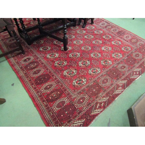 4492 - A Yomut Turkman red ground carpet, geometric design with multiple borders and tasselled ends, centra... 