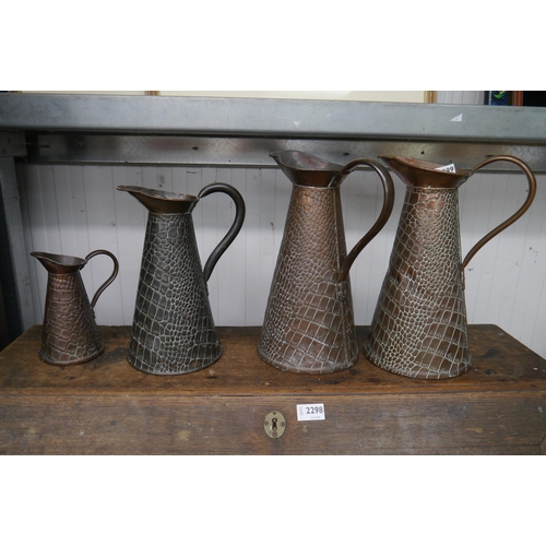 2299 - Four embossed copper jugs