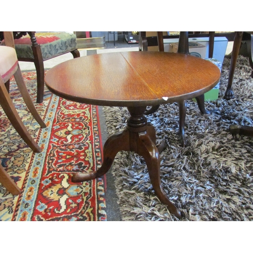 1054 - An oak circular top occasional table on a turned column and tripod base, 43cm tall x 53.5cm diameter... 