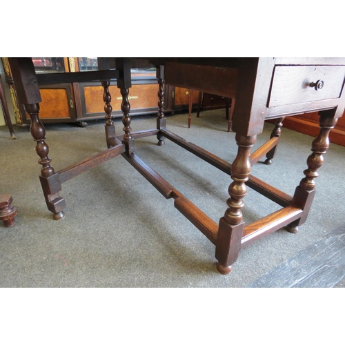 1028 - An 18th Century pegged oak oval plank top gate-leg dining table, the rising leaves over a single end... 