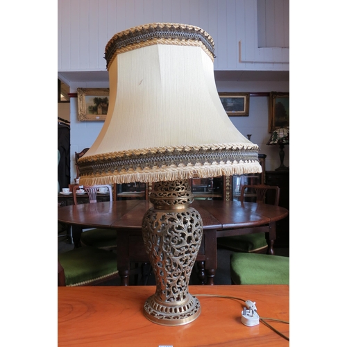 1029 - A reproduction pierced brass table lamp with scrolled foliate decoration, fluted tasselled shade