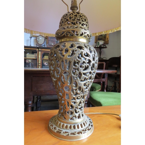 1029 - A reproduction pierced brass table lamp with scrolled foliate decoration, fluted tasselled shade