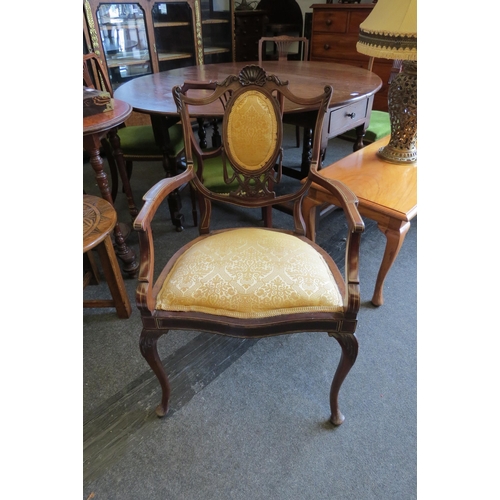 1031 - A Victorian carved mahogany inlaid armchair with oval panel backrest over a serpentine front seat on... 