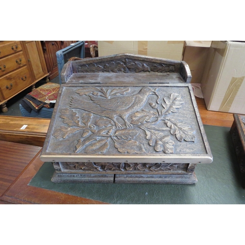 1098 - An early 20th Century carved oak writing slope, design of bird in an oak tree, repair to front, larg... 