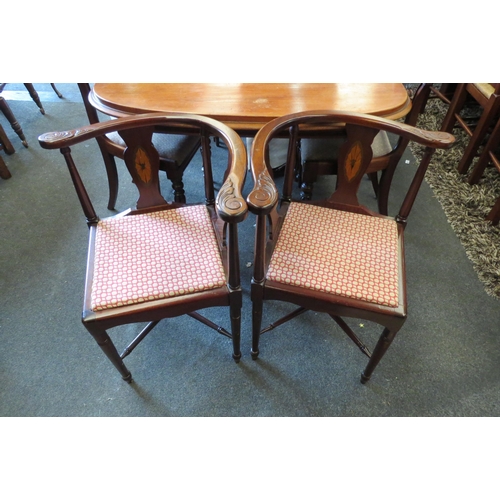 1125 - A pair of inlaid mahogany corner chairs on turned leg supports united by a turned 