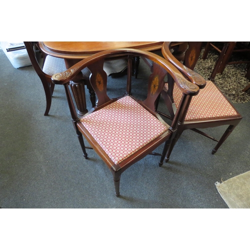 1125 - A pair of inlaid mahogany corner chairs on turned leg supports united by a turned 