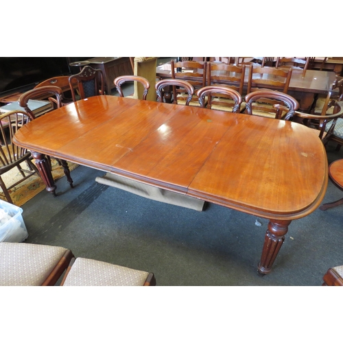 1131 - A Victorian mahogany round-cornered extending dining table, raised on turned and melon-fluted suppor... 