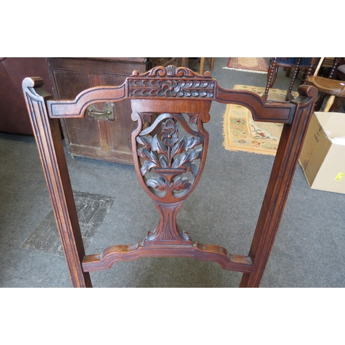 1140 - A Victorian nursing chair with floral pierced and carved back splat on ceramic castors