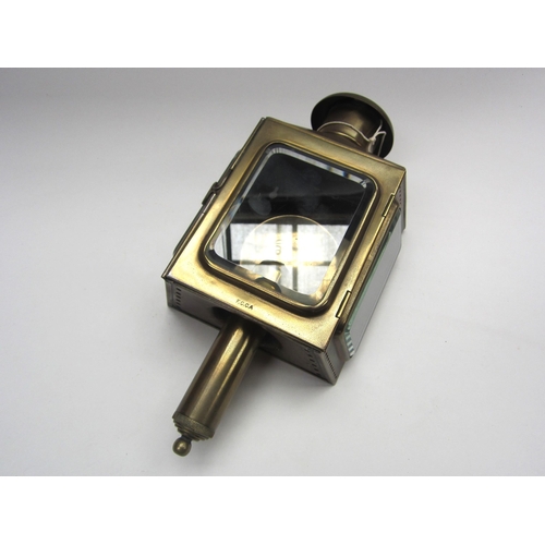 8197 - A brass carriage candle lamp with reflector plate interior and sprung loaded handle, stamped to bott... 