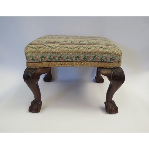 1002 - A tapestry footstool with cabriole legs on ball and claw feet