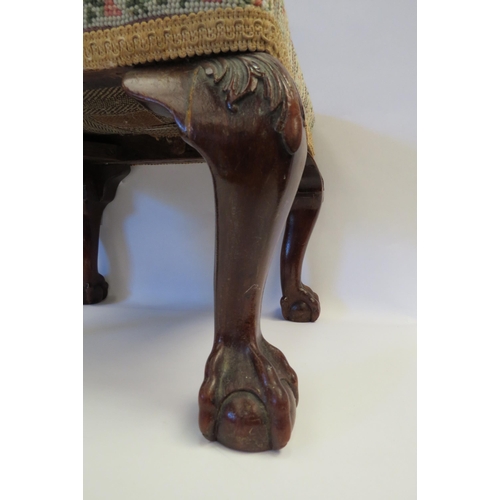 1002 - A tapestry footstool with cabriole legs on ball and claw feet