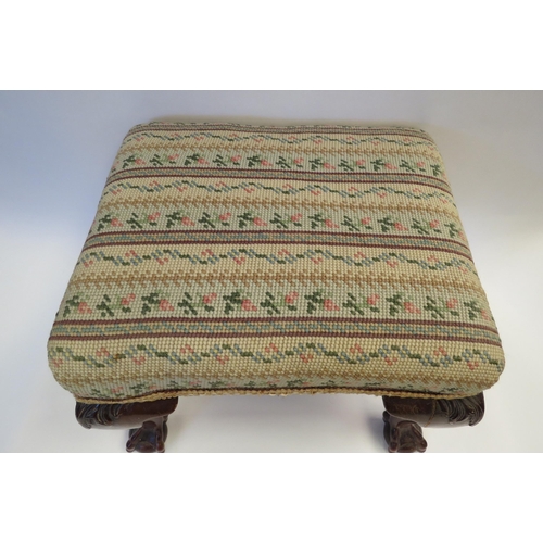 1002 - A tapestry footstool with cabriole legs on ball and claw feet