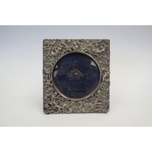 1273 - A silver photograph frame, pierced design of cherubs amongst foliage, 16cm tall, marks indistinct