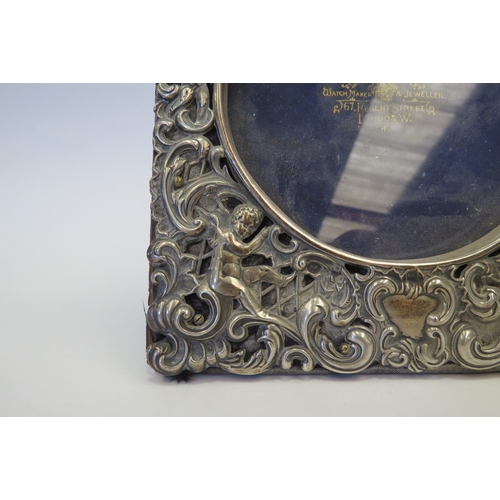 1273 - A silver photograph frame, pierced design of cherubs amongst foliage, 16cm tall, marks indistinct