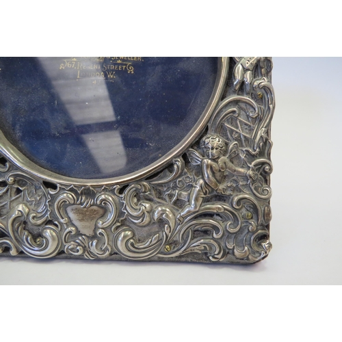 1273 - A silver photograph frame, pierced design of cherubs amongst foliage, 16cm tall, marks indistinct