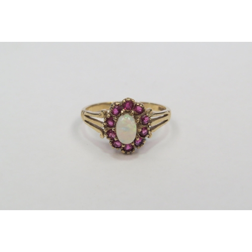 1303 - A 9ct gold opal and ruby set ring.  Approximately 2g