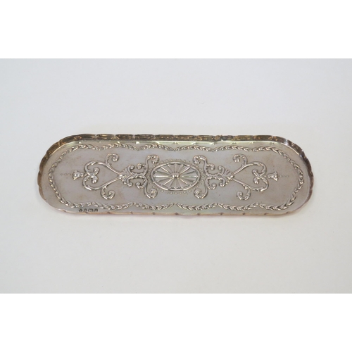 1318 - A silver dressing table tray with embossed decoration and shaped edge.  Length approximately 21cm.  ... 