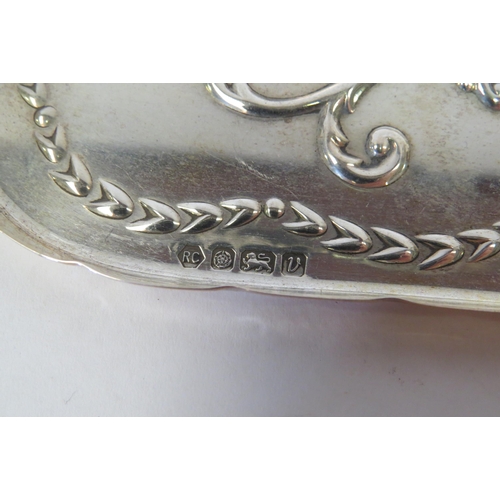 1318 - A silver dressing table tray with embossed decoration and shaped edge.  Length approximately 21cm.  ... 