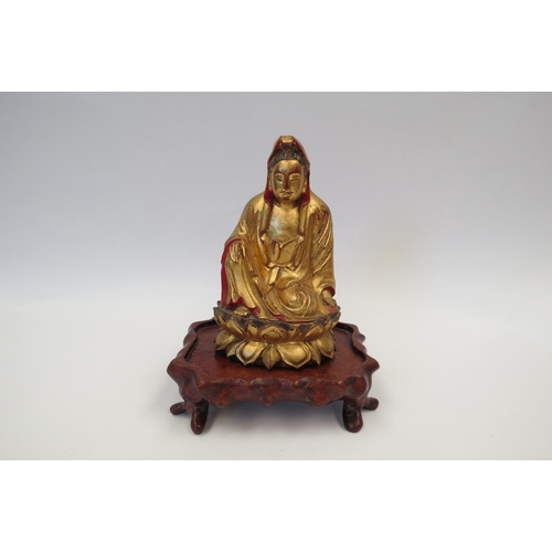 1324 - A gilt wood Buddha figure on associated hardwood base, the figure 15.5cm high