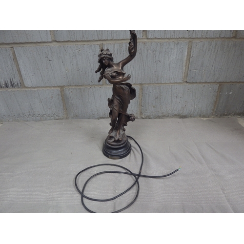 1083 - An electric figural table lamp, the bronzed metal figure of girl holding a bouquet with oversized pi... 