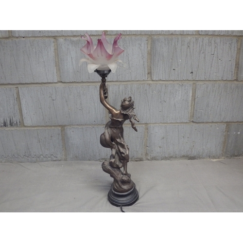 1083 - An electric figural table lamp, the bronzed metal figure of girl holding a bouquet with oversized pi... 