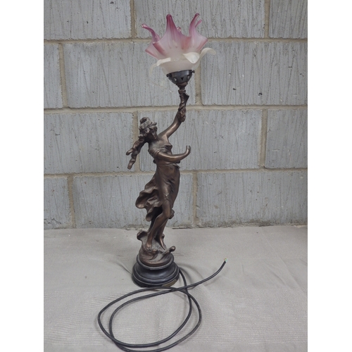 1083 - An electric figural table lamp, the bronzed metal figure of girl holding a bouquet with oversized pi... 