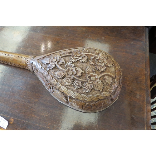 1443 - A heavily carved wooden single string guitar, floral pattern    (R) £15