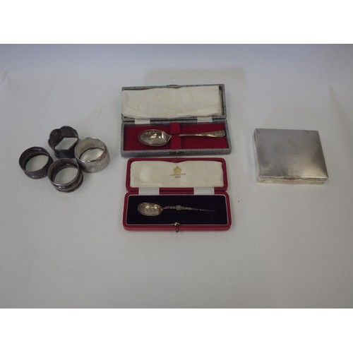 1090 - Four various silver napkin rings. A silver cigarette box, Birmingham 1955. Two boxed silver spoons i... 