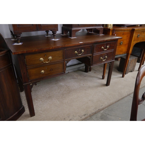 2121 - A late Georgian mahogany side table, five drawer front set with brass swan neck handles, central alc... 