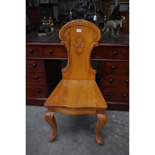 2210 - A pine hall chair with carved back