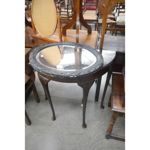 2221 - A demi-lune sidetable with a late Victorian ebonised decorative oval frame bevel edge mirror