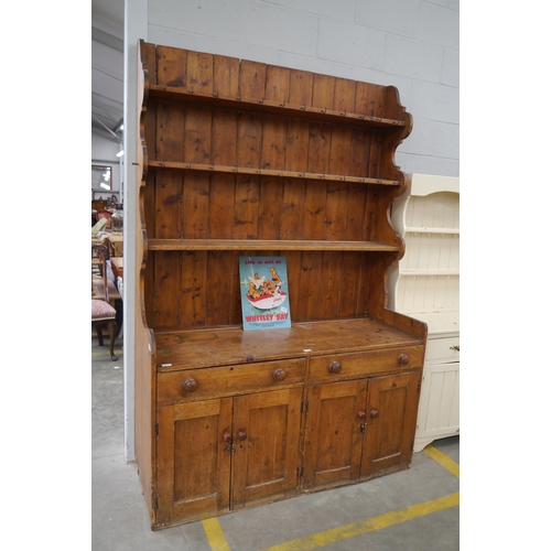 2328 - A 19th Century one piece pine dresser, the four tier plate rack back over a two drawer and four door... 