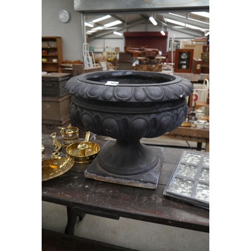 2024 - A black fibreglass semi-gadrooned urn, egg and dart rim, 40cm high, 50cm diameter