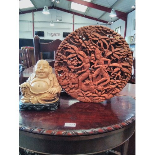 1114 - A resin figure of a seated Buddha together with a circular carved wall plaque (2)