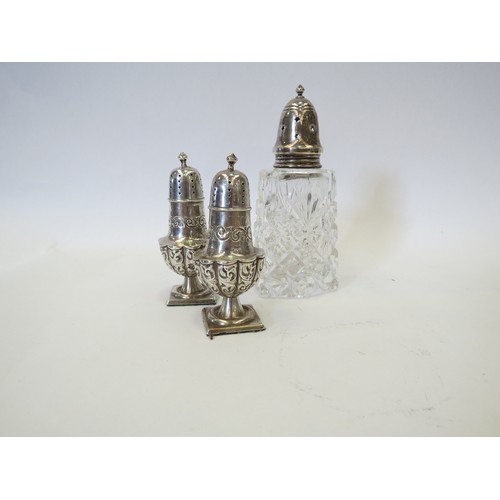 1087 - A pair of Edwardian silver pepperettes of pedestal baluster form, with repousse decoration. Birmingh... 