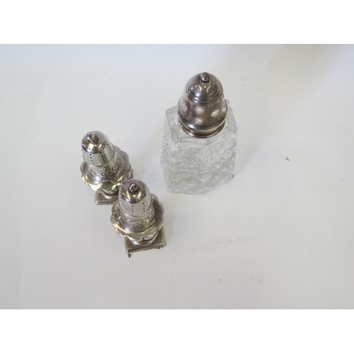 1087 - A pair of Edwardian silver pepperettes of pedestal baluster form, with repousse decoration. Birmingh... 