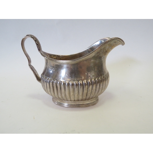 1093 - A Victorian silver milk jug of cushioned semi melon-fluted oval form. London 1884.
An Elizabeth II s... 