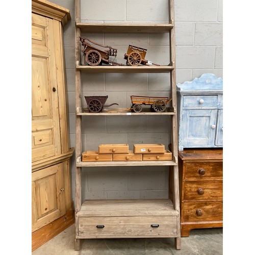 2311 - A pine full height set of ladder shelves, graduating depth, the base set with a drawer 233t x92cm