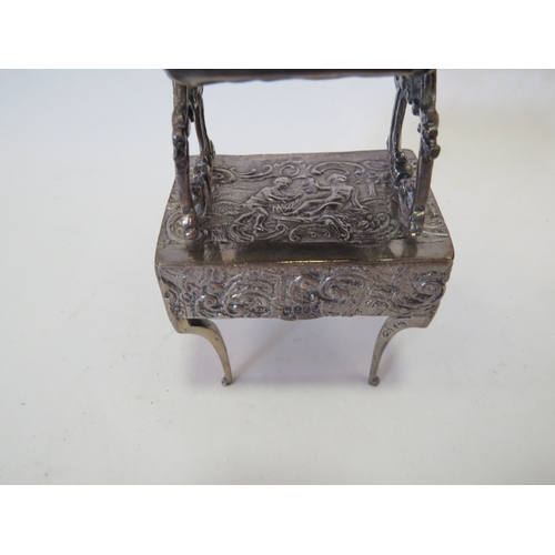 1101 - A Continental silver miniature dressing table with mirror. Two Continental repousse silver miniature... 