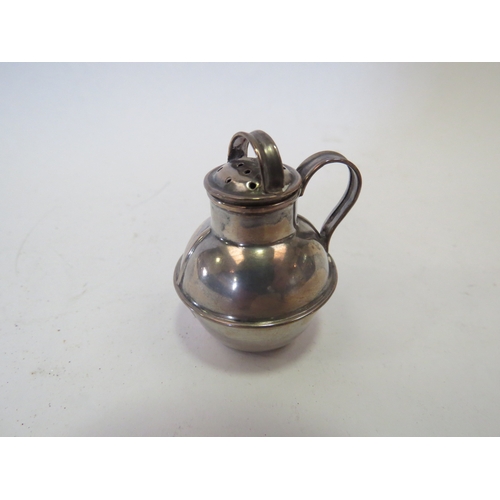 1104 - An Edwardian silver miniature pedestal paten London 1902 and a miniature pepperette as a Jersey milk... 