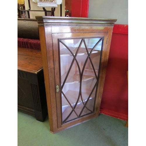 4055 - A George III mahogany wall hanging corner cabinet, the astragal glazed single door with key, having ... 