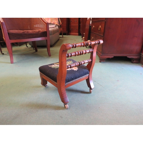 4244 - A Victorian child's chair with spindle back rails and tapestry floral seat on ceramic castors