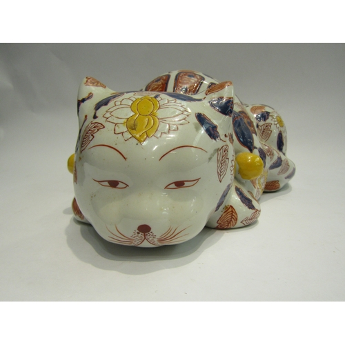 4013 - A Japanese ceramic recumbent cat, floral detailing, 32cm long