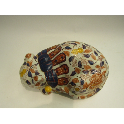 4013 - A Japanese ceramic recumbent cat, floral detailing, 32cm long