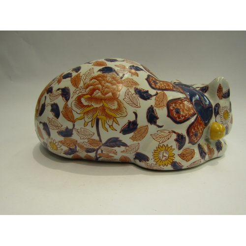 4013 - A Japanese ceramic recumbent cat, floral detailing, 32cm long