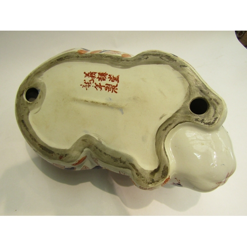 4013 - A Japanese ceramic recumbent cat, floral detailing, 32cm long