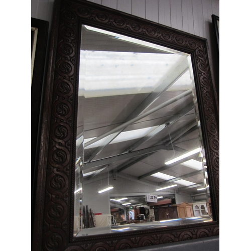 2379 - An oak carved bevelled edge mirror