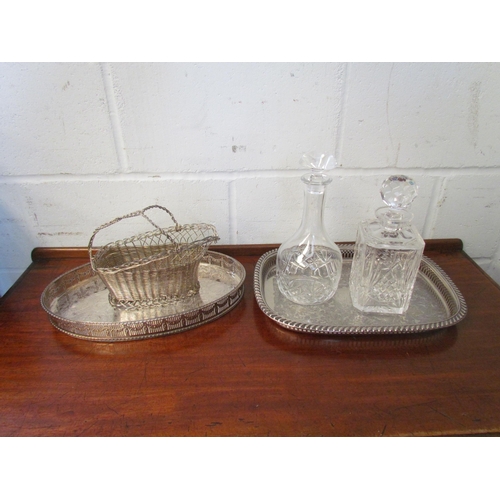 1210 - Two plated galleried trays, a wirework basket and two cut glass decanters (5)