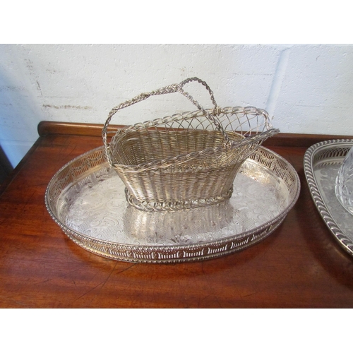 1210 - Two plated galleried trays, a wirework basket and two cut glass decanters (5)