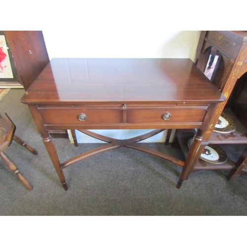 1221 - A mahogany two drawer writing table with red leather insert brushing slide on chamfered tapering leg... 